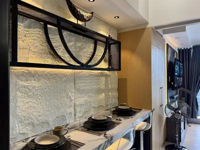 a kitchen with three pots and pans on a stove at Stylish 1br inside BGC at Uptown Parksuites - 24k in Manila