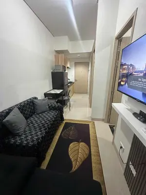 a living room with a couch and a flat screen tv at Leaf residences condotel 2bedroom Muntinlupa in Manila