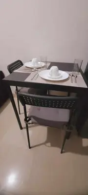 a black table with two plates and glasses on it at Leaf residences condotel 2bedroom Muntinlupa in Manila