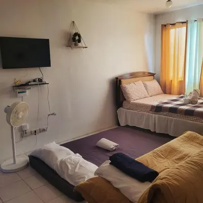a room with two beds and a flat screen tv at DJ's Staycation in Santa Rosa