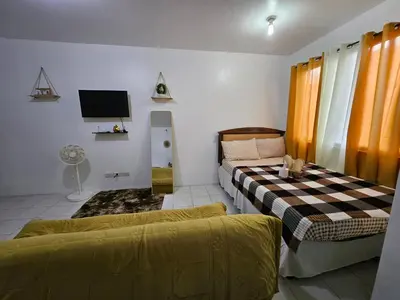 a living room with two beds and a tv at DJ's Staycation in Santa Rosa