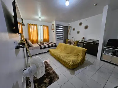 a living room with a yellow bed and a kitchen at DJ's Staycation in Santa Rosa