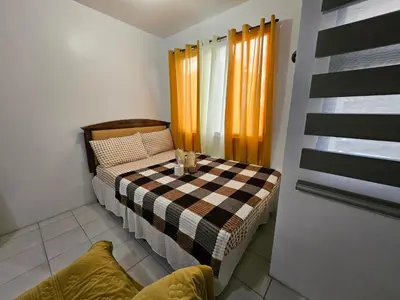 a small bedroom with a bed with a checkered blanket at DJ's Staycation in Santa Rosa