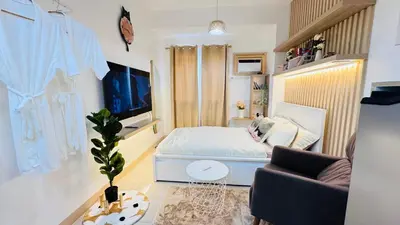 a small bedroom with a bed and a chair at Student Hub at DLSU in Pasong Bayog