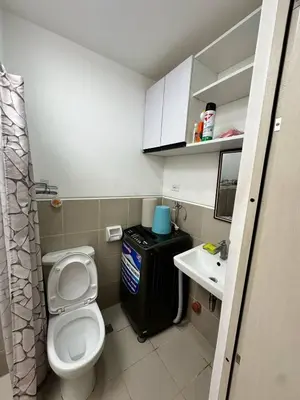 a small bathroom with a toilet and a sink at Cozy Condo at South Residences in Manila