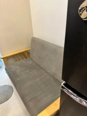 a gray couch in a room with a tv at Cozy Condo at South Residences in Manila
