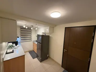 a kitchen with a black refrigerator and a counter at HAVEN on the 28th in Manila