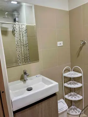 a bathroom with a white sink and a toilet at comfy 1 bedroom family condo in Manila