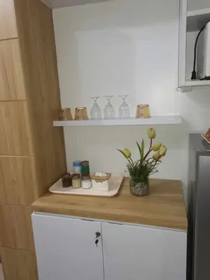 a kitchen counter with a plate and flowers on it at Shell Residences Family Suites 2 in Manila