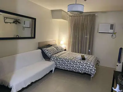 a hotel room with two beds and a window at Modern Studio Condominium 2 in Manila