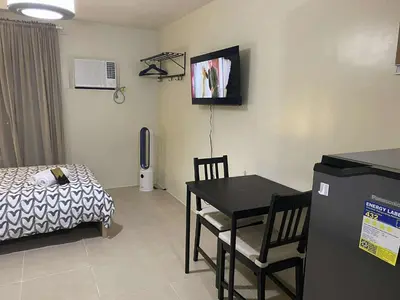 a small room with a bed and a table and chair at Modern Studio Condominium 2 in Manila