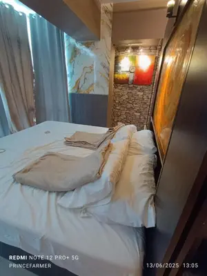 a bed with white sheets and pillows in a room at 1 Bedroom Red Oak Serendra BGC in Manila