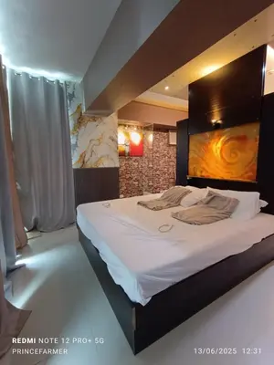 a bedroom with a large bed with a painting on the wall at 1 Bedroom Red Oak Serendra BGC in Manila