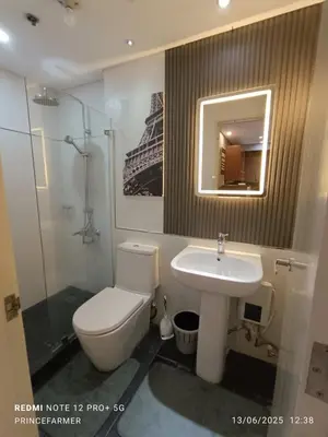 a bathroom with a toilet and a sink and a mirror at 1 Bedroom Red Oak Serendra BGC in Manila