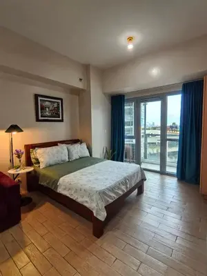 a bedroom with a bed and a large window at Classy Condotel Across NAIA Terminal 3 in Manila