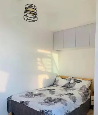 a bedroom with a bed with a white wall at Alabang Condos by Emma in Manila