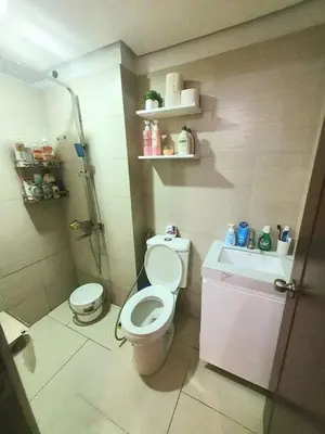 a bathroom with a toilet and a shower and a sink at Alabang Condos by Emma in Manila