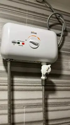 a white hair dryer hanging on a wall at Alabang Condos by Emma in Manila