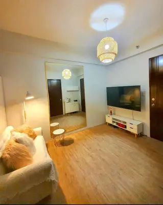 a living room with a couch and a flat screen tv at Alabang Condos by Emma in Manila
