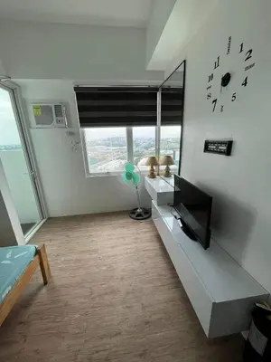a room with a tv and a clock on the wall at Alabang Condos by Emma in Manila