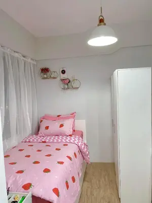 a bedroom with a bed with a pink comforter at Alabang Condos by Emma in Manila