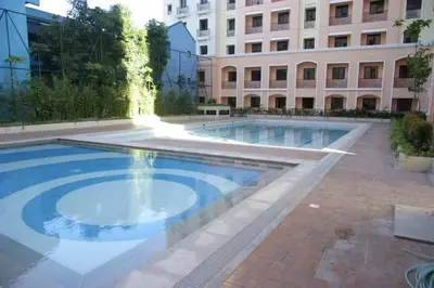 a large swimming pool in front of a building at Pinecrest residential resort in Manila