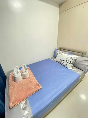 a bedroom with a bed with shoes on it at Ailyn staycation in Manila