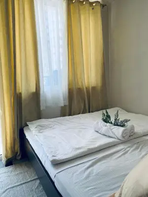 a bed with two towels and a window at Shore Escape PH in Manila