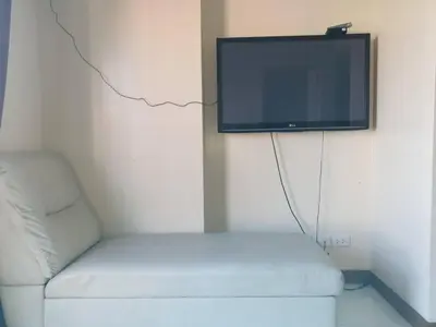 a living room with a couch and a flat screen tv at Peaceful City View Condo for Rent in Quezon City in Manila