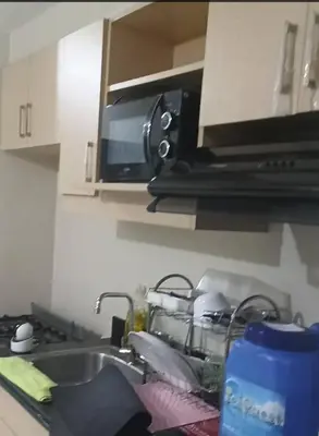 a kitchen counter with a sink and a microwave at Peaceful City View Condo for Rent in Quezon City in Manila