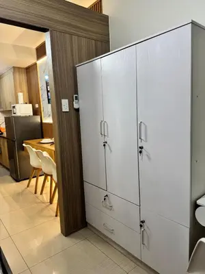 a large white cabinet in a kitchen with a table at Del Rosario Place Shore 2 Residence in Manila