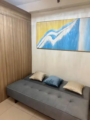 a bed in a room with a painting on the wall at Del Rosario Place Shore 2 Residence in Manila