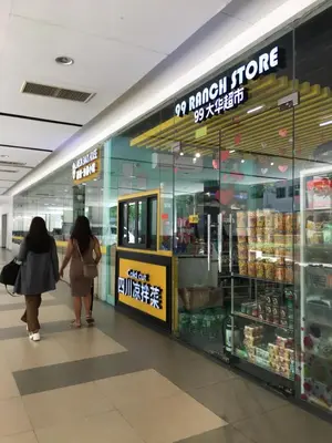 two people walking in front of a grocery store at Del Rosario Place Shore 2 Residence in Manila