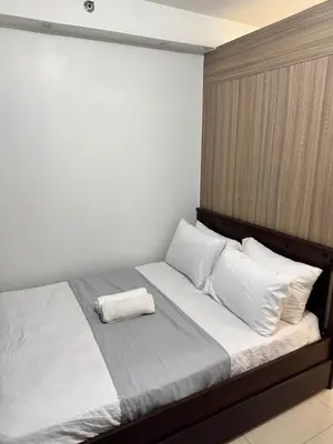 a bedroom with a bed with white sheets and pillows at Del Rosario Place Shore 2 Residence in Manila