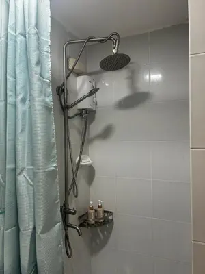 a shower in a bathroom with a shower curtain at Escapade Home in Manila