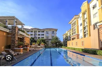 a swimming pool in the middle of two buildings at Escapade Home in Manila