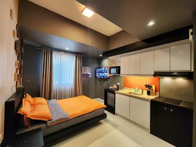 a small kitchen with a bed and a sink in a room at Private Unit at KL Tower Residences near Greenbelt Makati in Manila