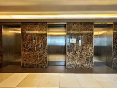 a row of elevator doors in a building at Private Unit at KL Tower Residences near Greenbelt Makati in Manila