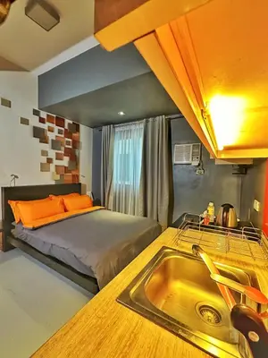 a kitchen with a bed and a sink in a room at Private Unit at KL Tower Residences near Greenbelt Makati in Manila