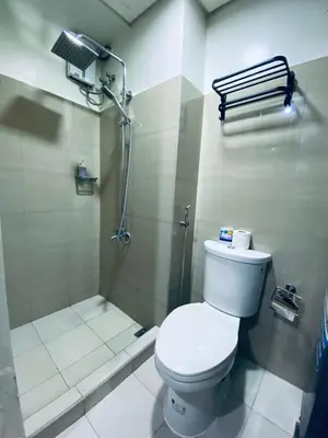 a bathroom with a toilet and a shower at AJ Staycation Shore 2 in Manila