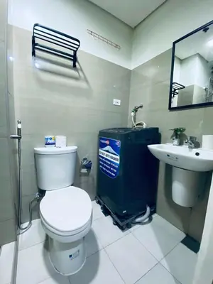 a bathroom with a toilet and a sink at AJ Staycation Shore 2 in Manila