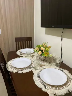 a table with two white plates and flowers on it at AJ Staycation Shore 2 in Manila