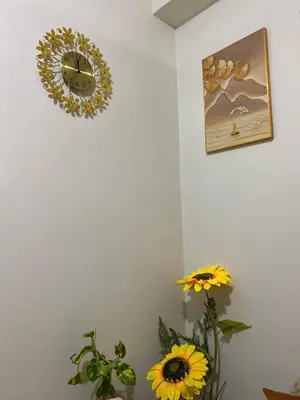 a clock on a wall next to a vase with flowers at AJ Staycation Shore 2 in Manila