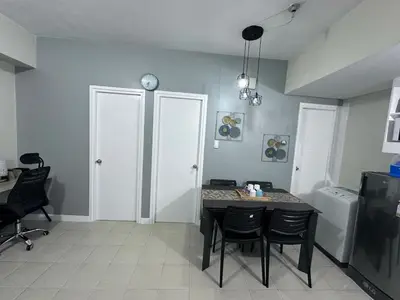 a dining room with a table and chairs in a room at Phebs 2bedroom with pool view in the heart of Makati in Manila