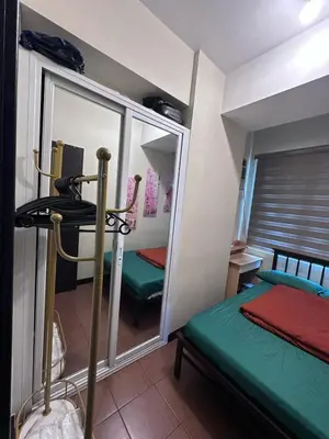 a small room with two beds and a mirror at Phebs 2bedroom with pool view in the heart of Makati in Manila