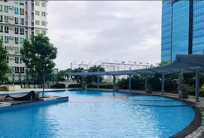 a large blue pool in a city with tall buildings at Phebs 2bedroom with pool view in the heart of Makati in Manila