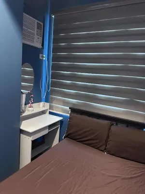 a bedroom with a bed and a desk and a mirror at Phebs 2bedroom with pool view in the heart of Makati in Manila