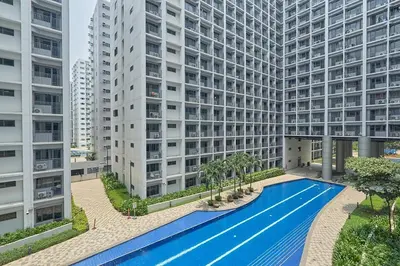 an apartment complex with a swimming pool in front of two tall buildings at MOA Shorescape City Life with WiFi in Manila