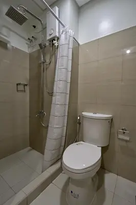 a bathroom with a toilet and a shower at MOA Shorescape City Life with WiFi in Manila