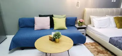 a living room with a blue bed and a table at Elite Pod Manila in Manila